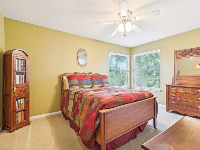 Bedroom with carpet flooring, baseboards, and a ceiling fan | Image 28
