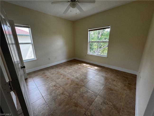 Spare room featuring ceiling fan, baseboards, and plenty of natural light | Image 8