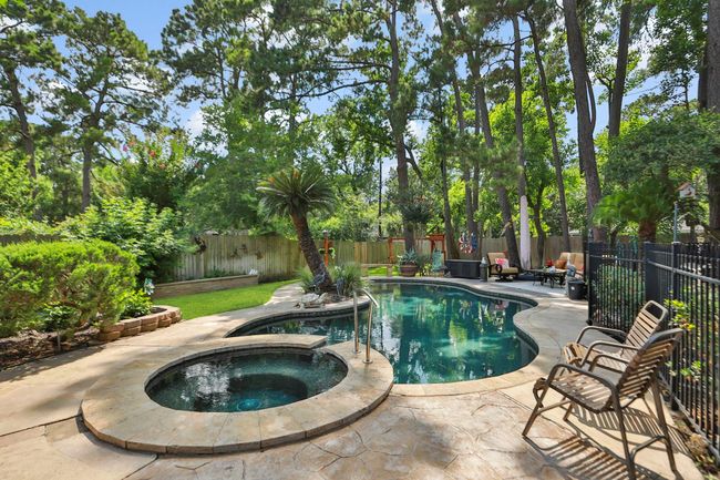 Private backyard oasis featuring a sparkling pool and spa surrounded by mature trees and lush landscaping. The expansive outdoor space includes a spacious patio area perfect for entertaining, while the secluded setting provides the ultimate retreat for relaxation and recreation. | Image 27