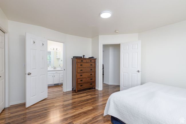 Bedroom with dark wood-style floors, baseboards, and ensuite bath | Image 10