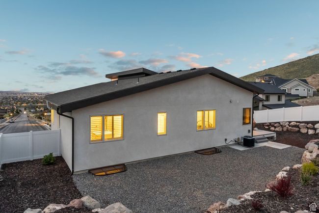 Back of property at dusk featuring central air condition unit, stucco siding, and a fenced backyard | Image 85