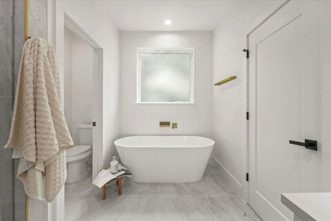 Bathroom with a freestanding tub, toilet, marble finish flooring, and recessed lighting | Image 17