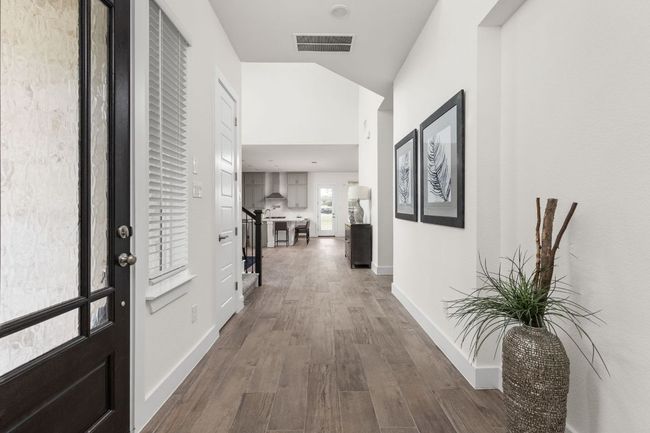 Corridor with dark wood-style floors, baseboards, and lofted ceiling | Image 7