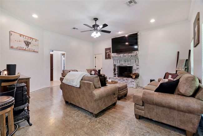Living room featuring recessed lighting, visible vents, a ceiling fan, crown molding, and a brick fireplace | Image 5