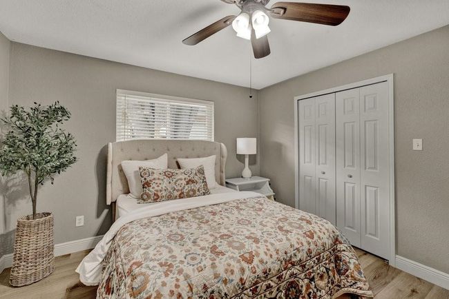 Bedroom with baseboards, a closet, ceiling fan, and wood finished floors | Image 18