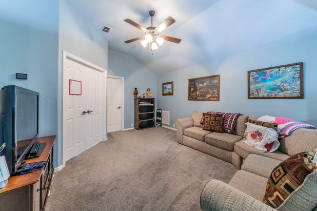 Living room with a ceiling fan, carpet floors, lofted ceiling, and baseboards | Image 24
