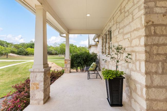 The covered front porch offers a peaceful spot to enjoy your morning coffee while taking in the serene Hill Country surroundings. | Image 4