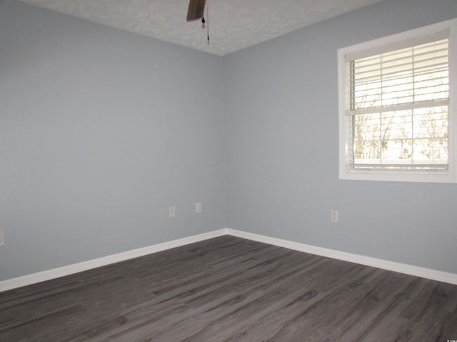 Bedroom with LVP flooring and a ceiling fan. | Image 12