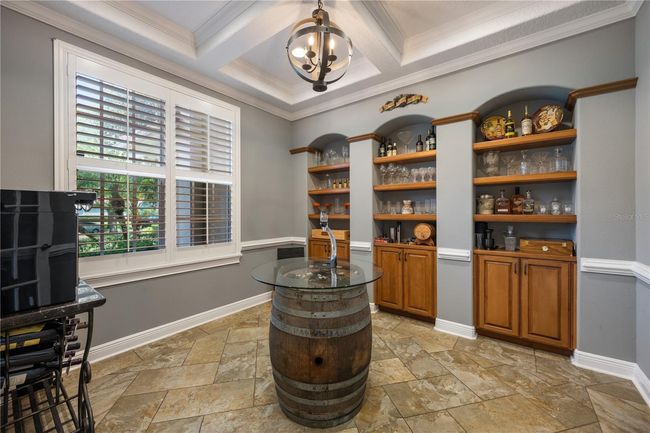 Office with coffered ceiling, trim work, plantation shutters and custom built-ins. Currently being used as a wine room! (not included in bedroom count) | Image 12