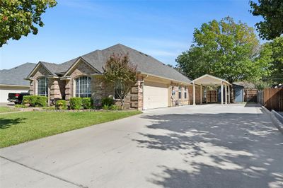 Ranch-style house featuring a front lawn and a garage | Image 2