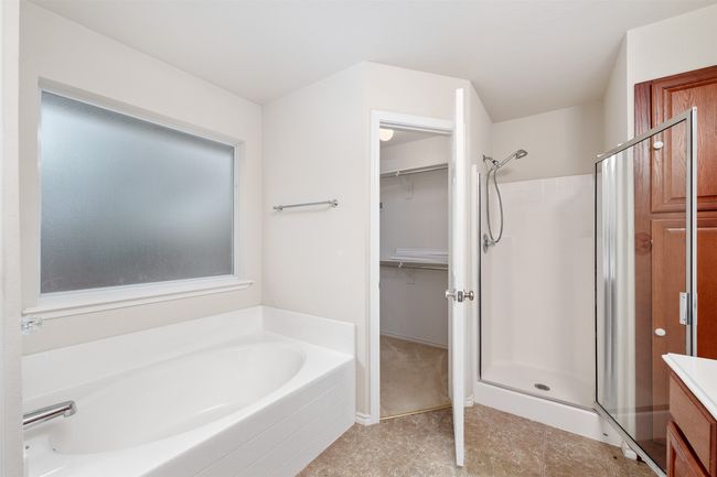 Bathroom featuring a shower, a spacious closet, and a garden tub | Image 13