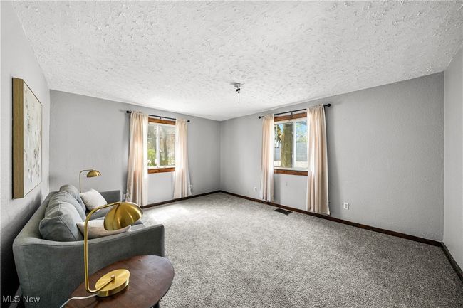 Living area with baseboards, plenty of natural light, a textured ceiling, and carpet floors | Image 11