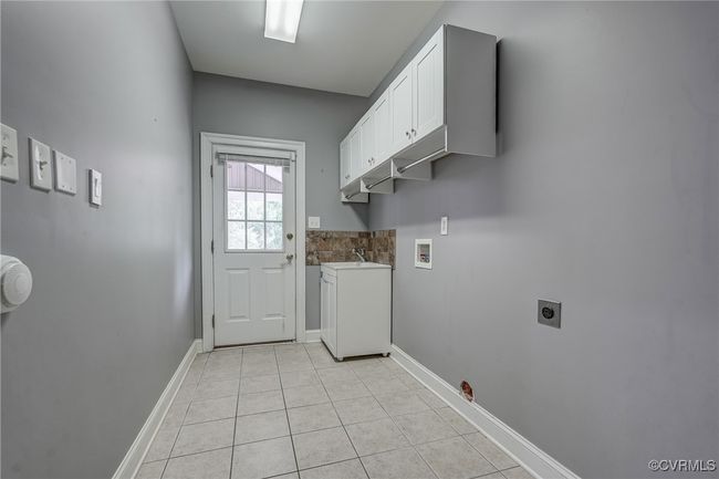 Spacious laundry/mud room with convenient access to both the backyard and garage—ideal for daily function and organization. | Image 28
