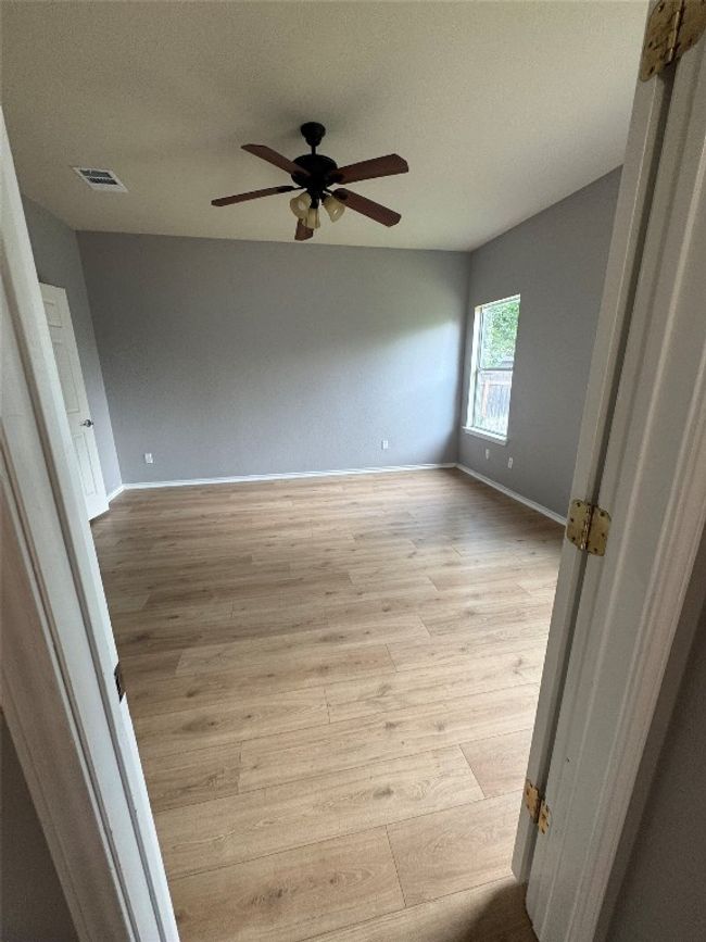Empty room with a ceiling fan, light wood-type flooring, and baseboards | Image 16
