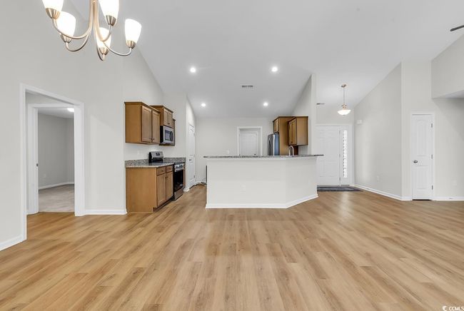 Kitchen featuring appliances with stainless steel finishes, high vaulted ceiling, brown cabinetry, and baseboards | Image 31