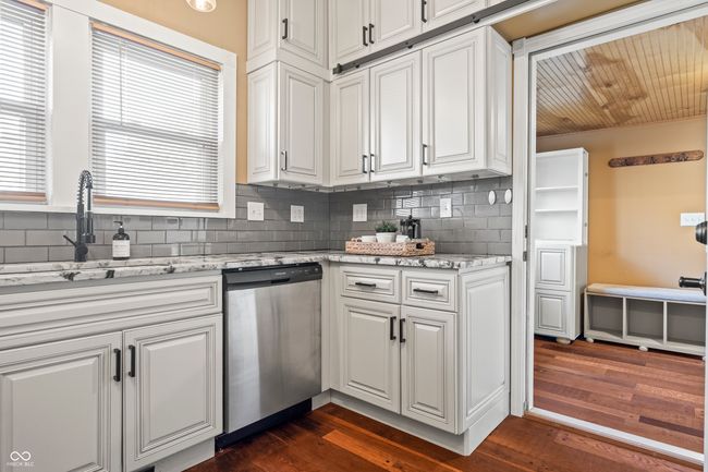 kitchen featuring white cabinetry, light stone counters, and decorative backsplash | Image 46