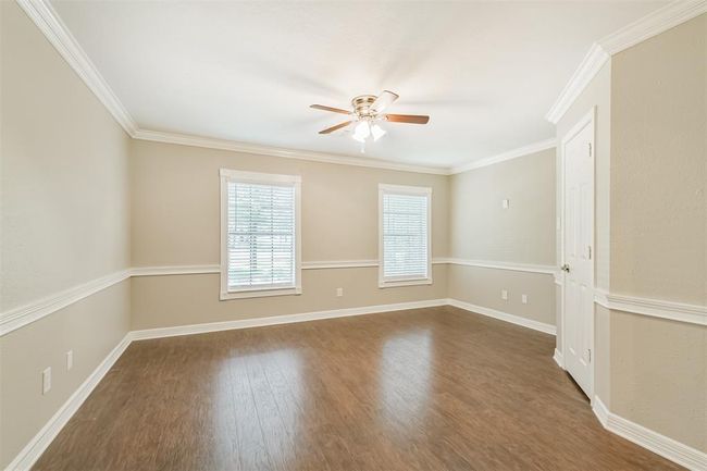 Upstairs Bedroom 2 features a spacious walk-in closet, ceiling fan, and sleek flooring. | Image 30