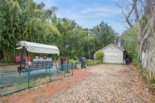 View of patio with an outdoor structure, grilling area, fence, and a garage | Image 28