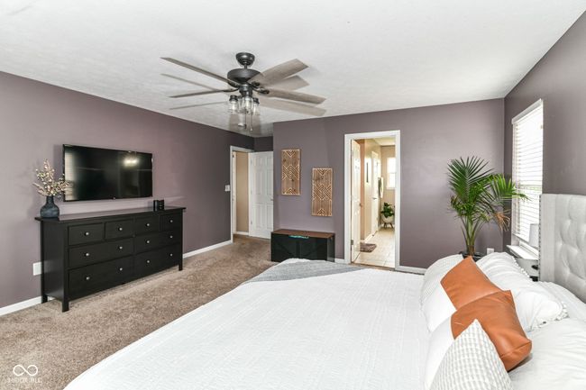 bedroom featuring carpet floors, baseboards, connected bathroom, and ceiling fan | Image 12