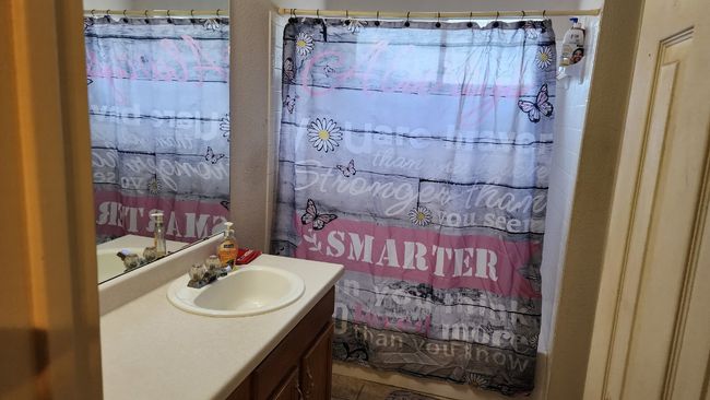 Bathroom featuring vanity, curtained shower, and tile patterned flooring | Image 10