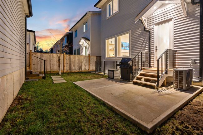 Yard at dusk featuring a patio area, fence, and central AC | Image 29