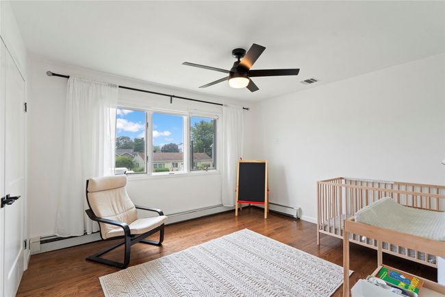 Bedroom featuring wood finished floors, a desk, a closet, and ceiling fan | Image 28