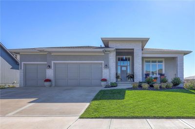 Prairie-style house with a porch, a front yard, and a garage | Image 2