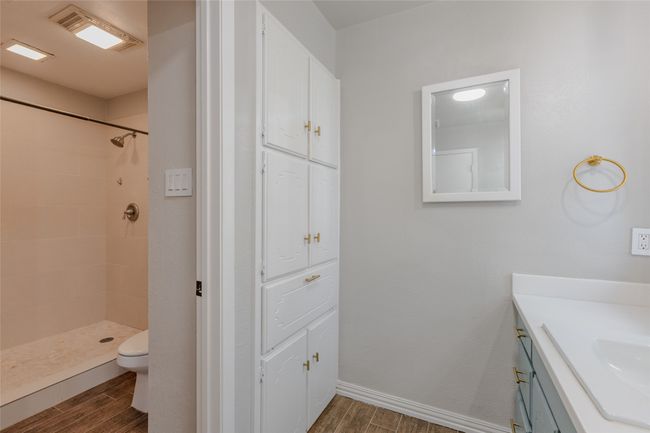 Full bath with wood finished floors, vanity, and a tile shower | Image 18