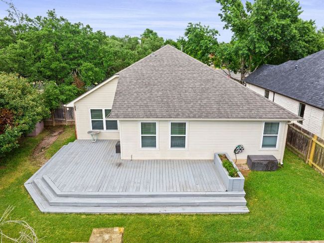 Back of property featuring a fenced backyard, a shingled roof, and a deck | Image 26