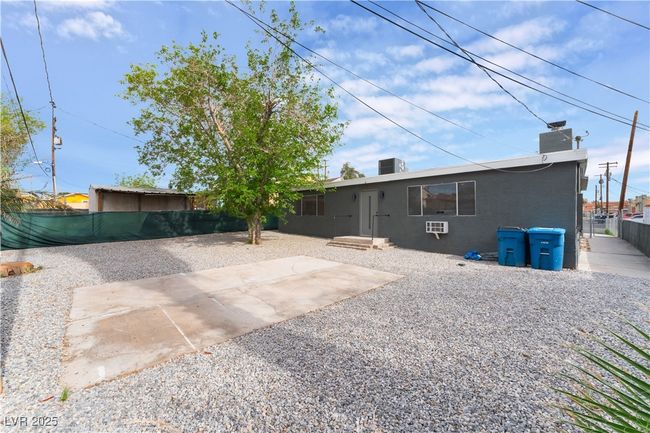 Rear view of property featuring a chimney, central AC unit, fence, and a patio | Image 33