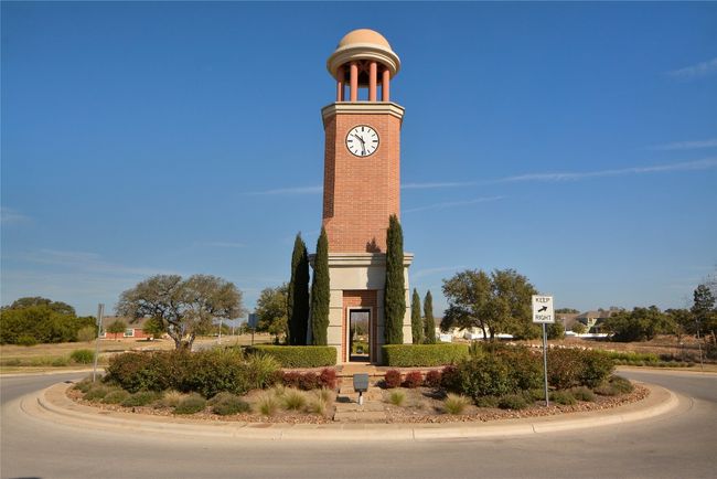 At the neighborhood entrance, a huge clock tower in the center of a roundabout greets you with a small-town vibe, tree-lined streets, and charming architecture. | Image 34