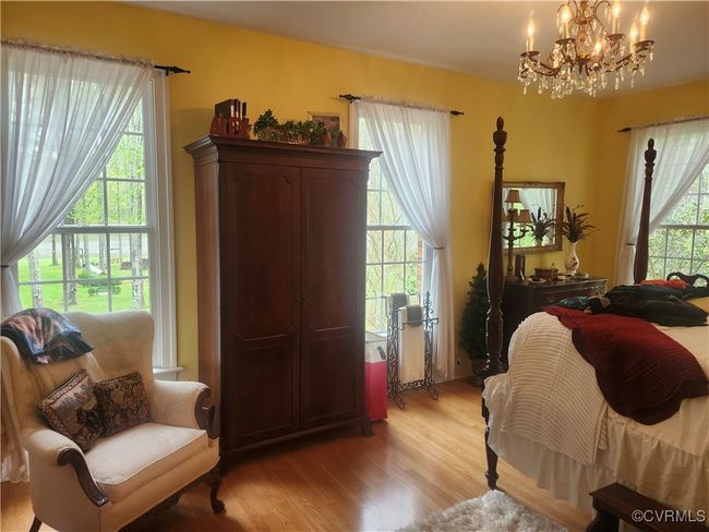 3rd Bedroom with light wood finished floors and a notable chandelier | Image 11