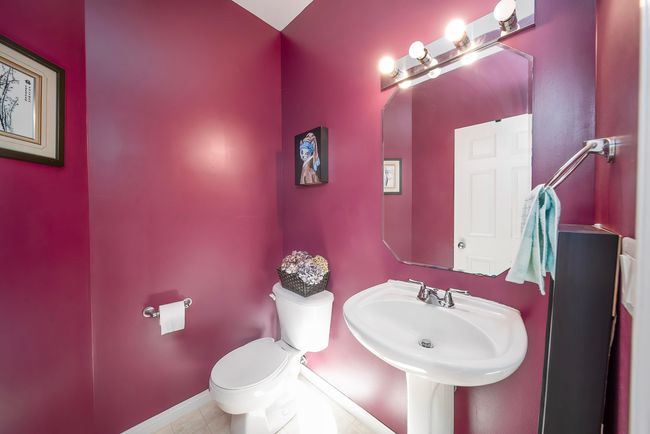 Bathroom with tile patterned flooring, toilet, baseboards, and a sink | Image 30