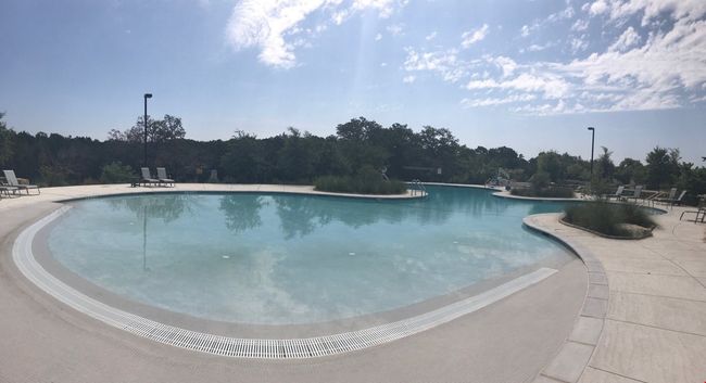 Community pool featuring a forest view and a patio area | Image 22