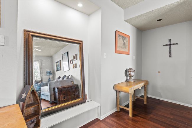 Corridor with baseboards, a textured ceiling, and dark wood finished floors | Image 13