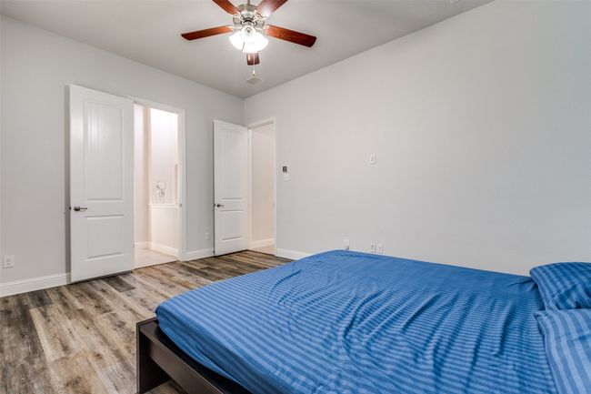 Bedroom featuring a ceiling fan, visible vents, wood finished floors, and baseboards | Image 20