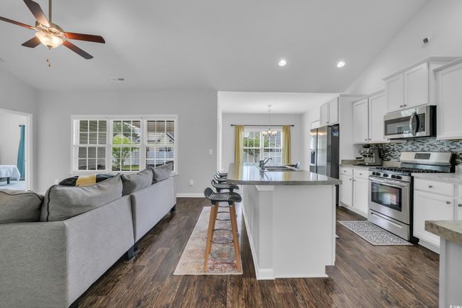 Kitchen with tasteful backsplash, a sink, open floor plan, stainless steel appliances, and lofted ceiling | Image 28