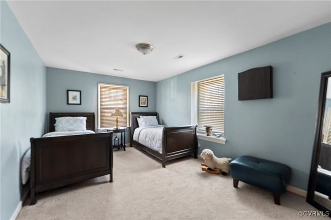 Bedroom featuring visible vents, multiple windows, light colored carpet, and baseboards | Image 34