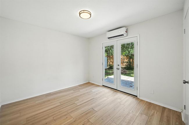 Unfurnished room featuring a wall mounted AC, french doors, and light wood-type flooring | Image 15