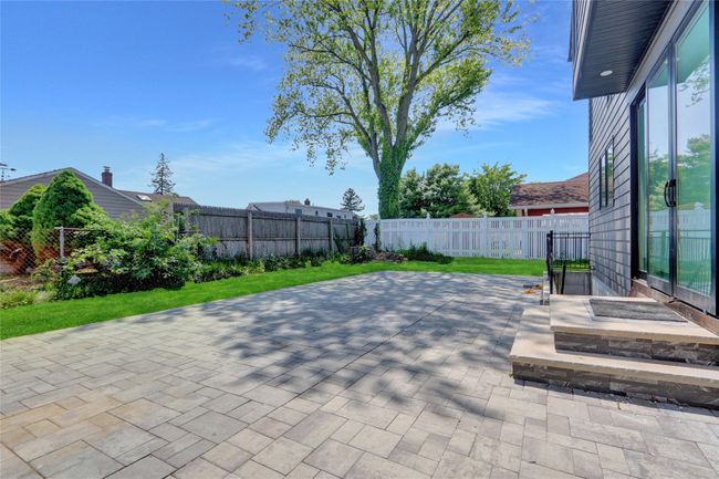 Fenced backyard with a patio area | Image 31