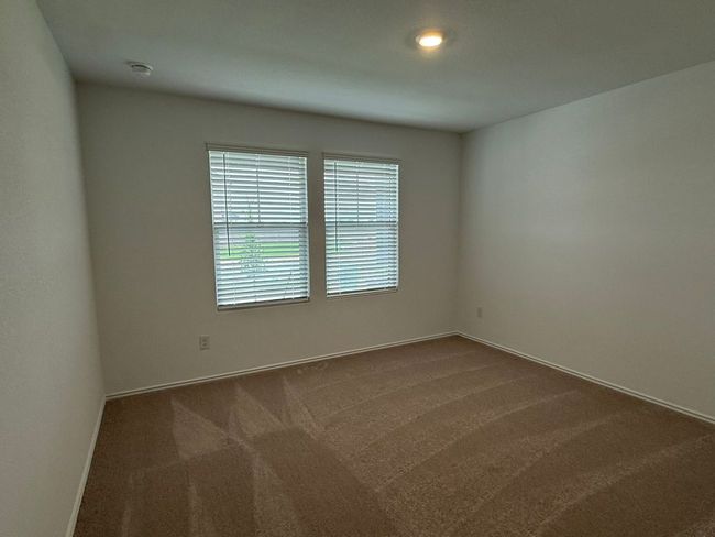 Spare room with dark colored carpet, baseboards, and a smoke detector | Image 7