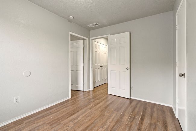 Unfurnished bedroom featuring wood finished floors, baseboards, and a textured ceiling | Image 22