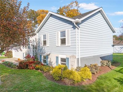 View of side of property featuring a lawn and a garage | Image 3