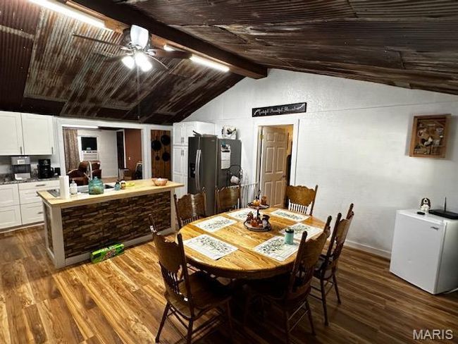 Dining space featuring lofted ceiling with beams, ceiling fan, wooden ceiling, and dark hardwood / wood-style flooring | Image 11