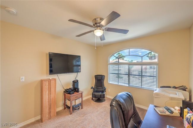 Carpeted office space featuring a ceiling fan and baseboards | Image 9