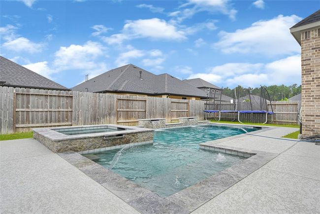 Backyard oasis with hot tub and heated pool with waterfalls. | Image 30