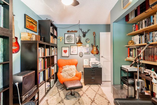 Sitting room with a textured ceiling, a desk, and a ceiling fan | Image 17