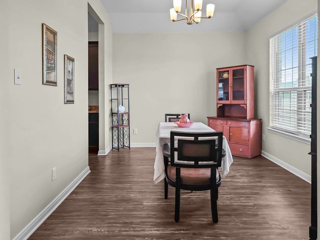 Dining space with a chandelier, dark wood finished floors, plenty of natural light, and vaulted ceiling | Image 12