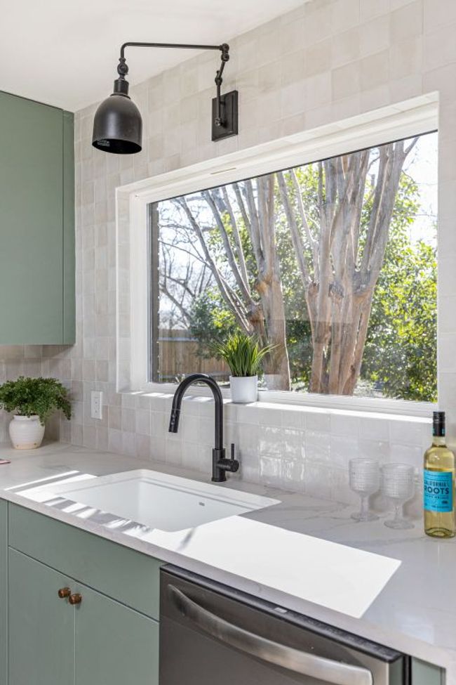 Kitchen featuring stainless steel dishwasher, green cabinetry, and decorative backsplash | Image 21