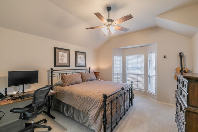 Bedroom with baseboards, light colored carpet, ceiling fan, and vaulted ceiling | Image 20